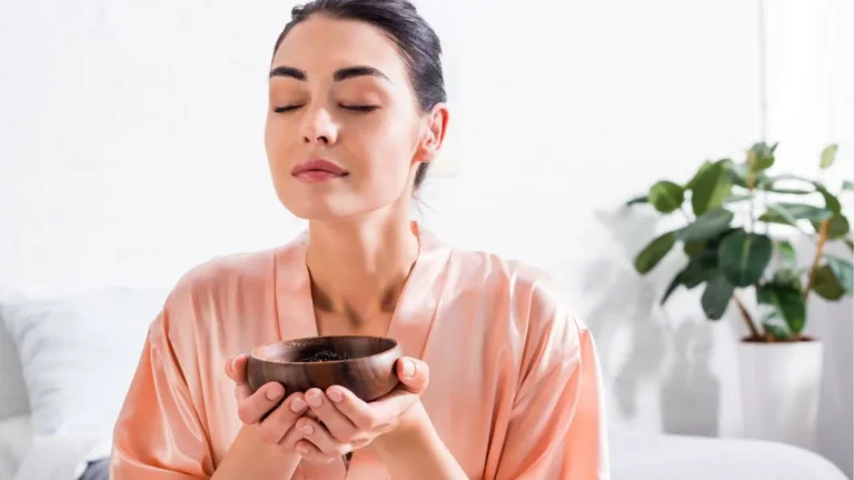 Czy aromaterapia jest zdrowa? Odkryj fakty i mity 6 Kobieta stosująca aromaterapię poprzez wdychanie zapachu z miski, ilustrująca dyskusję na temat zdrowotnych aspektów aromaterapii